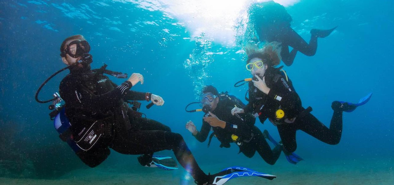 Buceador principiante guiado por un monitor de Aquasport Diving